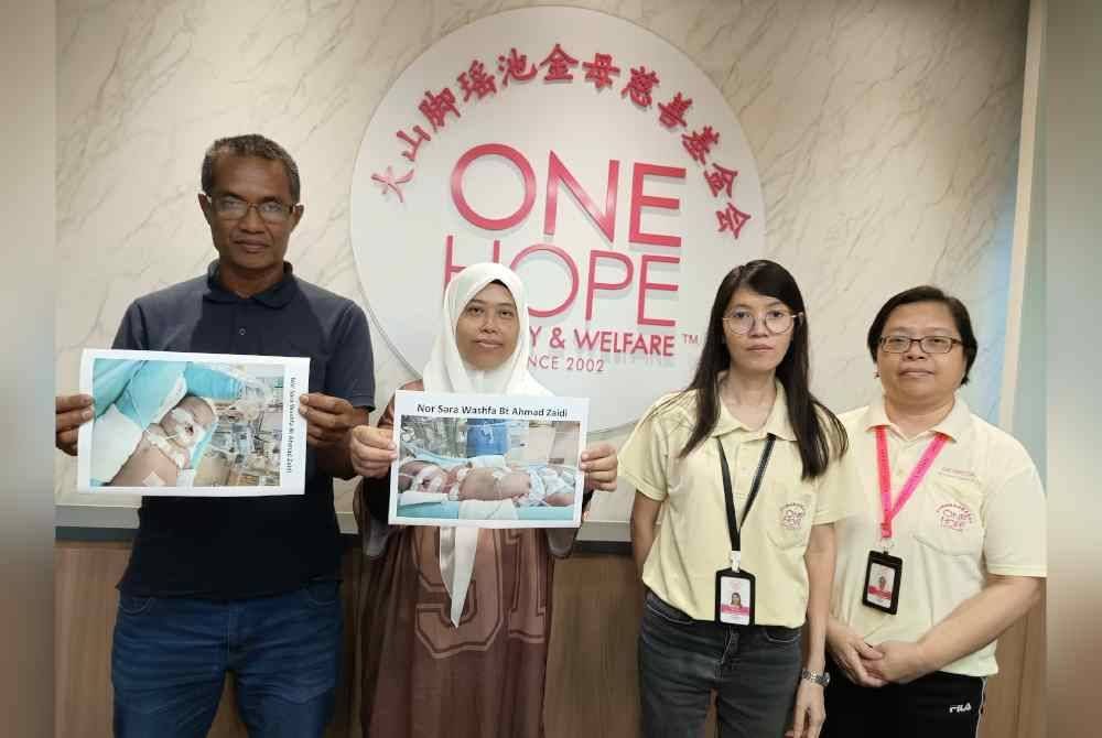 Ahmad Zaidi (kiri) dan isterinya Masrini ketika bertemu dengan pegawai One Hope Charity & Walfare bagi mendapatkan bantuan.
