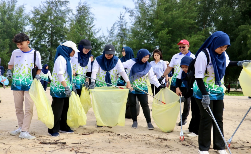 Norliza Abdul (lima dari kiri) bersama para peserta sedang melakukan aktiviti pembersihan Kawasan Pantai Cherating, Pahang.