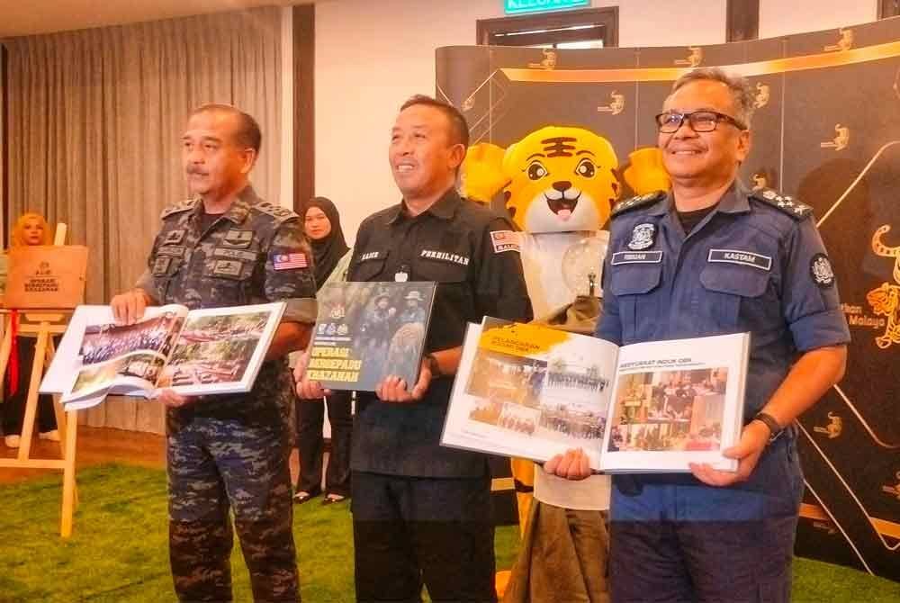 Razarudin (kiri) dan Abdul Kadir (tengah) dan Ribuan bersama buku OBK yang turut dilancarkan sempena mesyuarat tersebut.