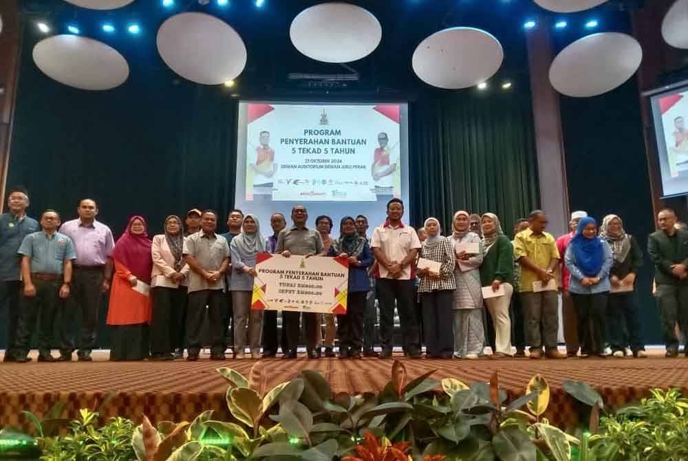 Izham (tengah) menyempurnakan penyerahan bantuan sempena Majlis Penyerahan Bantuan 5 Tekad 5 Tahun Kerajaan Negeri Selangor pada Isnin.