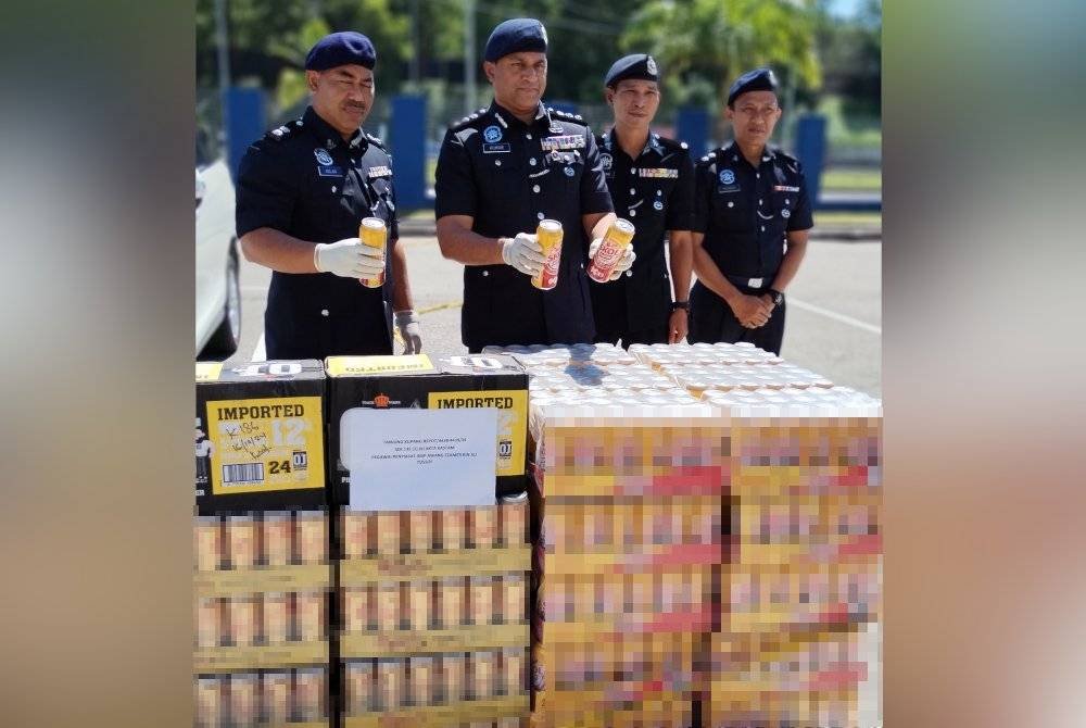 Kumarasan (dua dari kiri) menunjukkan arak seludup yang dirampas dalam dua serbuan berasingan di sekitar kawasan Gelang Patah, di Iskandar Puteri, minggu lalu.