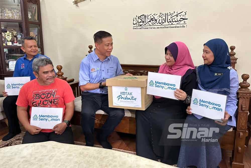 Rahmat (tiga dari kiri) turut menyampaikan bakul makanan daripada PERKESO kepada Nik Nazura (dua dari kanan).