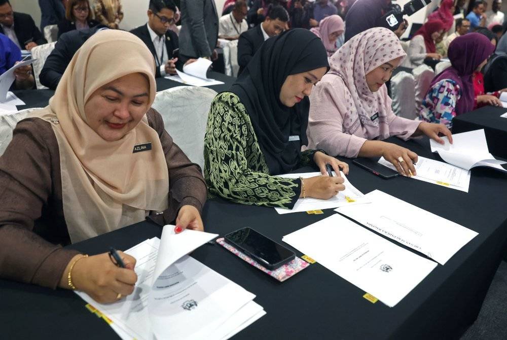 Sebahagian daripada 75 penjawat awam menandatangani borang SSPA di Kompleks C, Pusat Pentadbiran Kerajaan Persekutuan pada Isnin. Foto Bernama