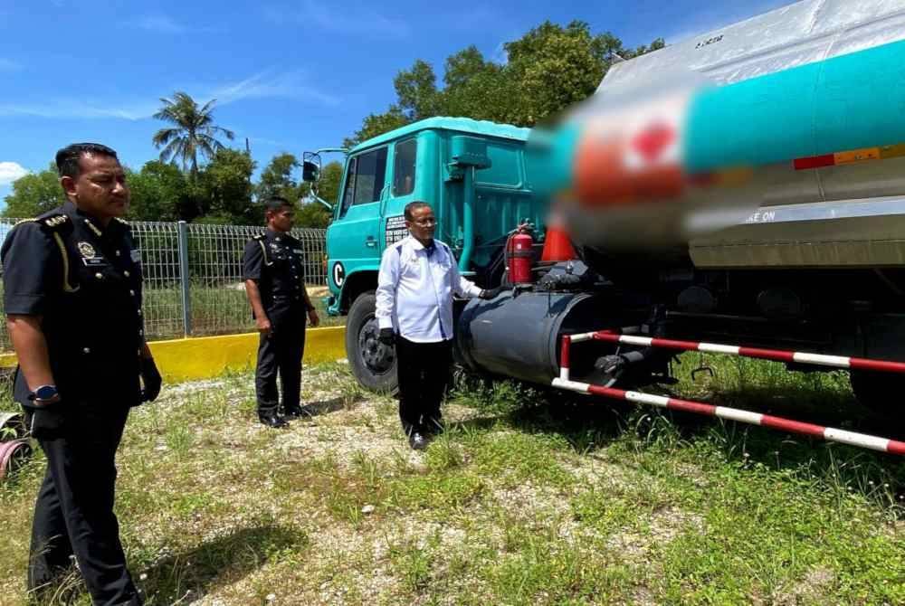 Azman (kanan) menunjukkan sebahagian daripada kenderaan yang disita.