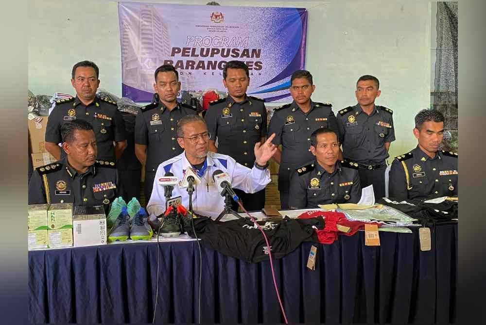 Azman (dua dari kiri) semasa sidang media Program Pelupusan Barang Kes di stor penyimpanan KPDN di Kandis, Bachok pada Selasa.