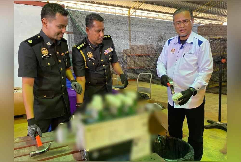 Azman (kanan) hadir pada Program Pelupusan Barang Kes di stor penyimpanan KPDN di Kandis, Bachok pada Selasa.