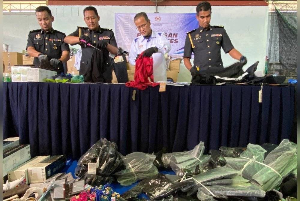 Azman (dua dari kanan) bersama barangan yang akan dilupuskan dan kebanyakannya melibatkan Akta Kawalan Bekalan 1961, Akta Perihal Dagangan 2011, Akta Timbang Sukat 1972, Akta Cap Dagang 2019 dan Akta Pelindungan Pengguna 1999.