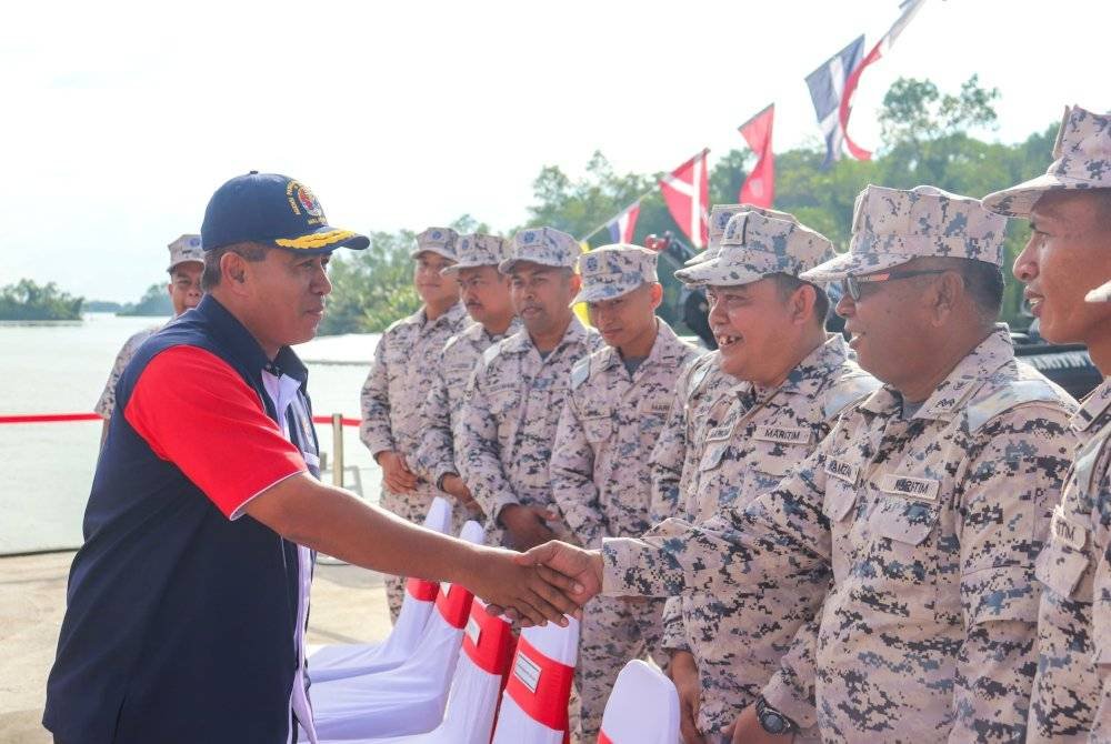 Saiful Lizan (kiri) bersalaman bersama anggota Maritim Malaysia sempena Majlis Penyerahan KM Sebatik bagi Perolehan Repowering Jentera Utama dan Refit yang berlangsung di Kuala Terengganu, pada Selasa.