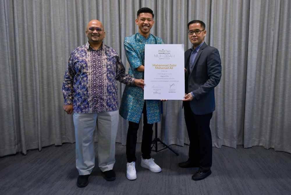 Zubir Khan (tengah) menerima Anugerah Macrokiosk Muhibbah daripada Ketua Pegawai Eksekutif Macrokiosk Datuk Kenny Goh (kanan) pada majlis penyampaian Anugerah Macrokiosk Muhibbah di Plaza Conlay. Foto Bernama