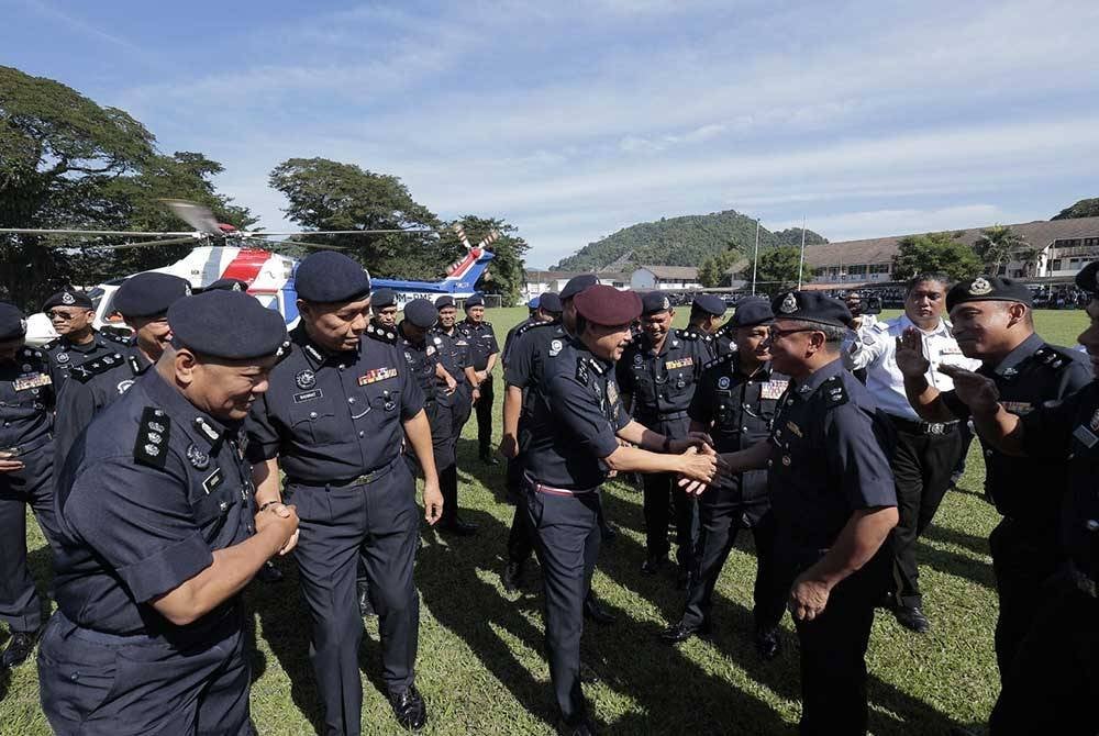 Mohd Yusri (tiga dari kanan) bersalaman dengan pegawai-pegawai sebaik tiba di SMK Anderson, Ipoh.