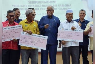 Mahfuz (tengah) beramah mesra bersama wakil penerima bantuan tabung bencana tanaman padi dan penyerahan peruntukan program ladang benih pada Rabu.