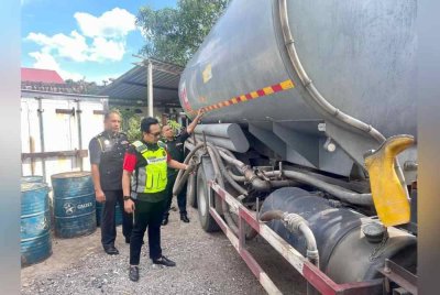 Kamalludin memeriksa lori tangki yang dirampas dalam kegiatan penyelewengan diesel di sebuah stor haram di Kampung Melayu Jenderata, Hutan Melintang pada Selasa. Foto Ihsan KPDN Perak