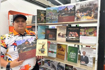 Amirul Firdaus menunjukkan buku-buku berunsurkan warisan yang boleh didapati pada Karnival Semarak Ilmu.