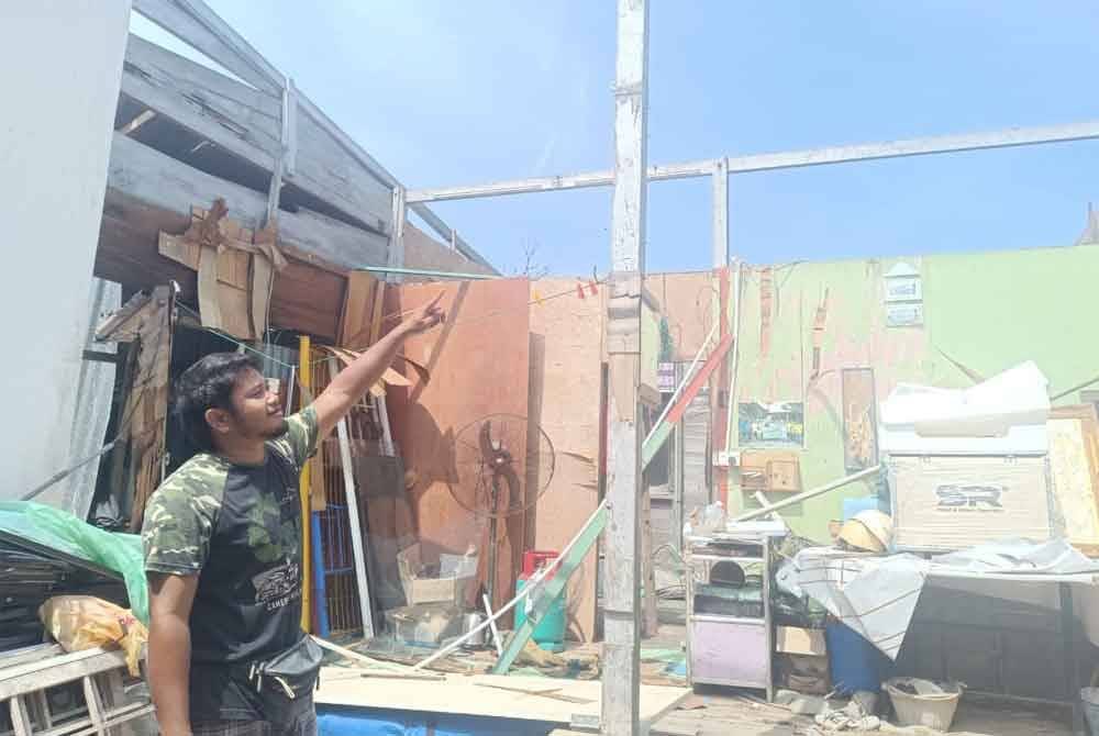 Mawardi menunjukkan keadaan atap rumah yang diterbangkan ribut.