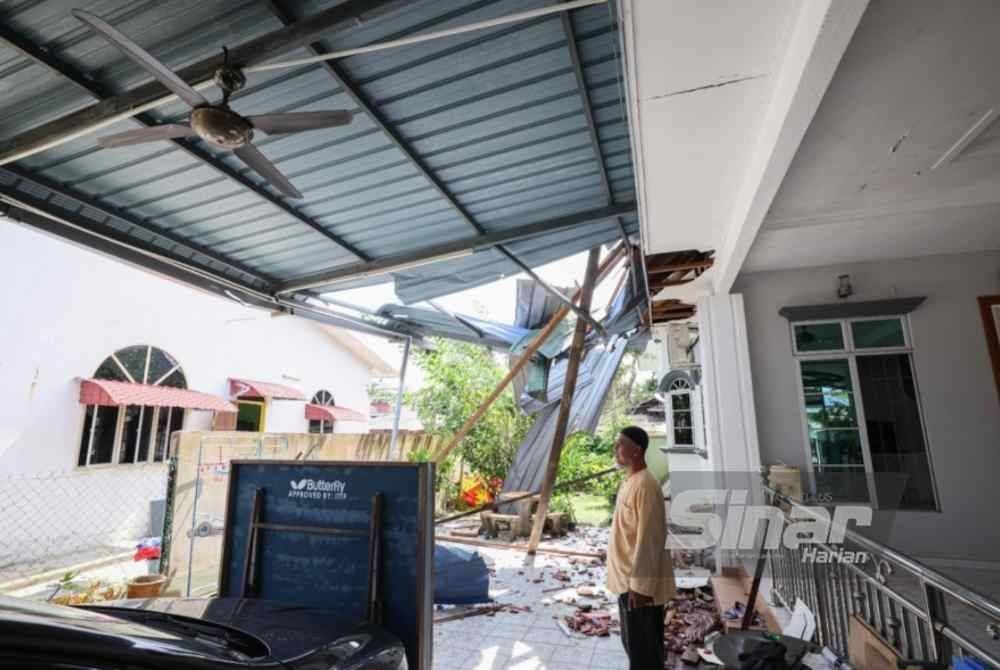 Abdullah Zawawi menunjukkan keadaan rumah yang mengalami kerosakan akibat ribut pada petang Rabu.