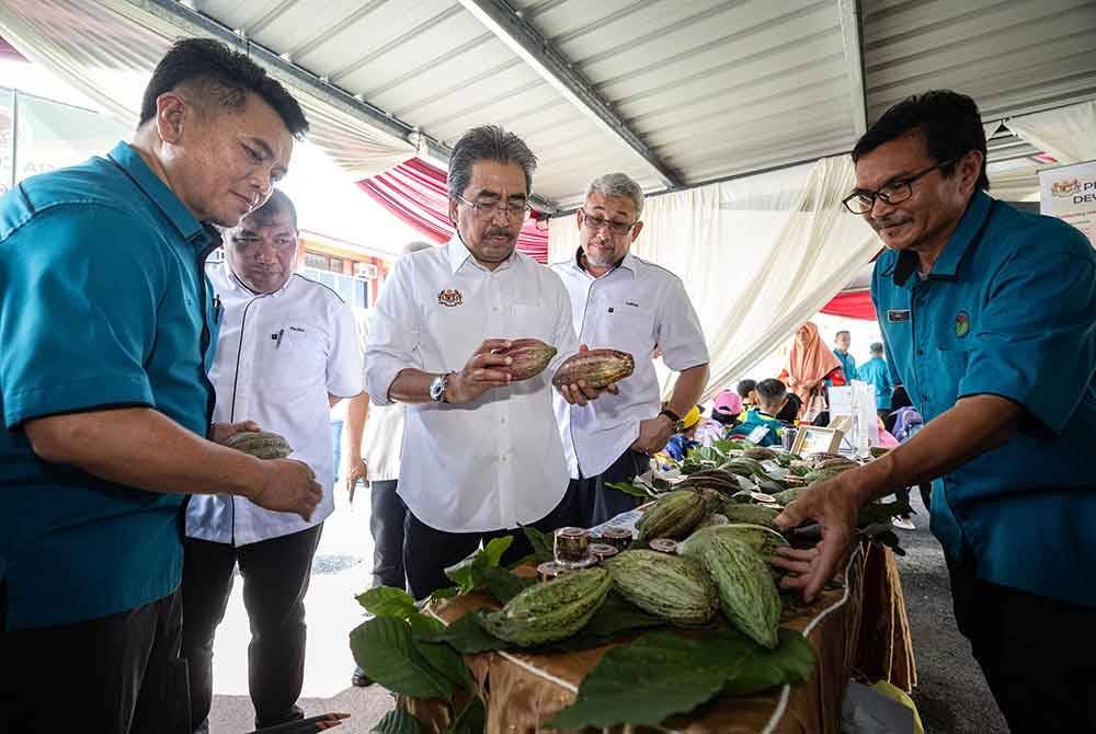 Johari (tiga dari kiri) melihat buah koko yang dipamerkan ketika melawat reruai selepas merasmikan Hari Terbuka Lembaga Koko Malaysia (LKM) Bagan Datuk 2024 di LKM Sungai Sumun hari ini. Foto Bernama