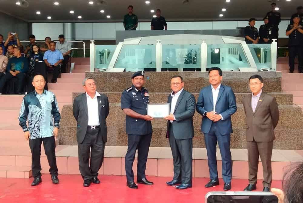 Amirudin (tiga kanan) menyerahkan cenderahati kepada Hussien yang mewakili polis Selangor