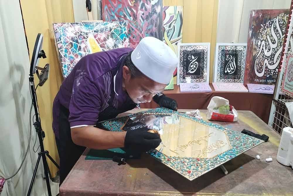Mohd Hamdan melakar tulisan khat menggunakan piping bag atau beg krim pastri untuk hasil yang memuaskan.
