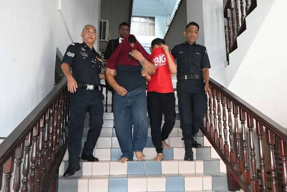 Mohamad Nizam (dua dari kiri) dan rakannya Shahrizan (tiga dari kiri) ketika dibawa keluar dari mahkamah majistret pada Jumaat.