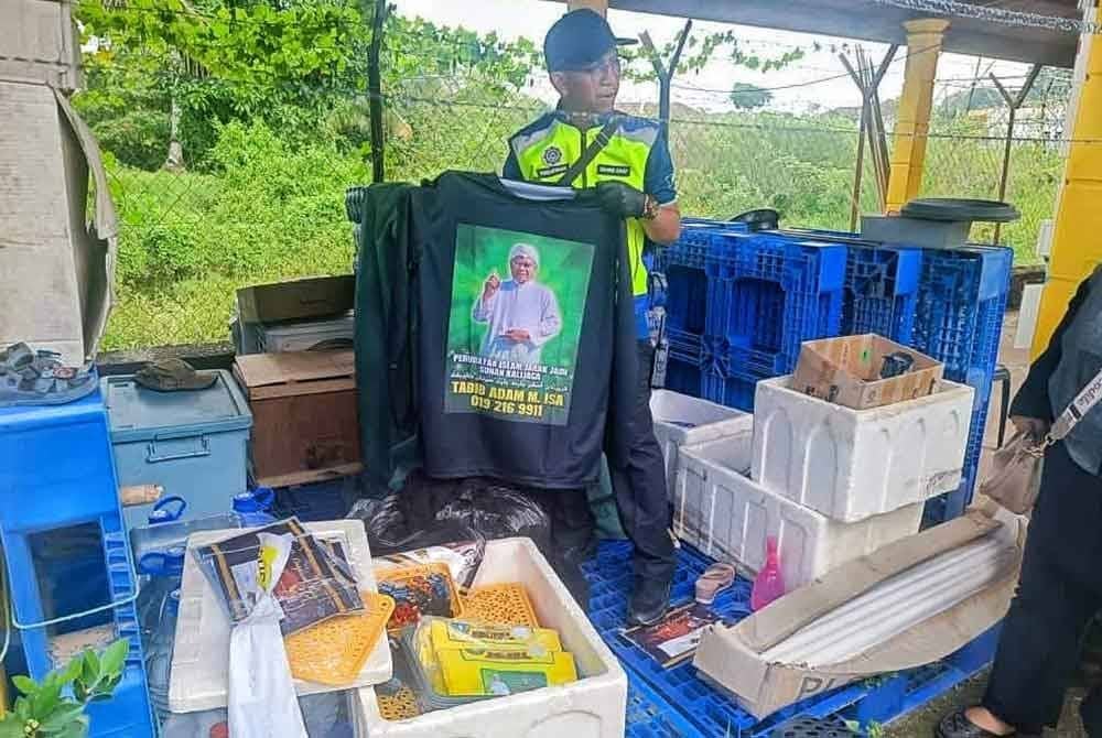 Pegawai penguat kuasa JAIM menemui baju yang terpampang gambar pemilik premis berkenaan yang menjalankan perubatan jarak jauh di Masjid Tanah.