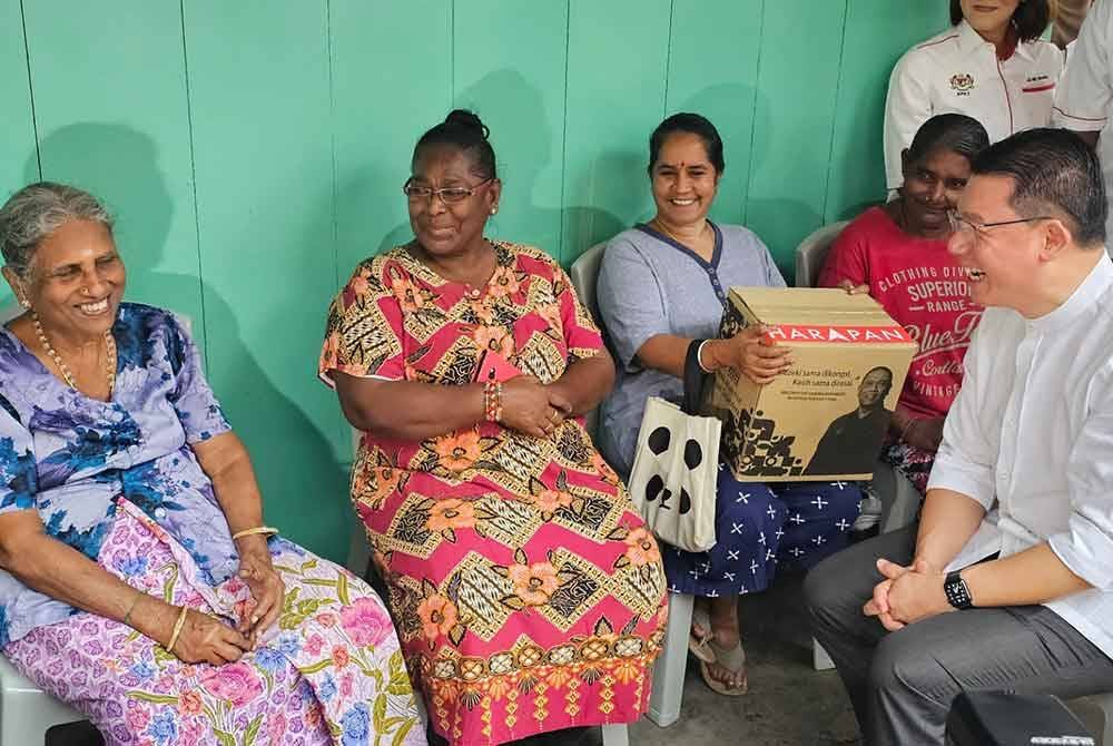 Kor Ming beramah mesra dengan penduduk, K Panjawarnan, 49 (kiri) dalam lawatan dan perasmian Pusat Komuniti KRT Jalan Hospital di Ipoh.