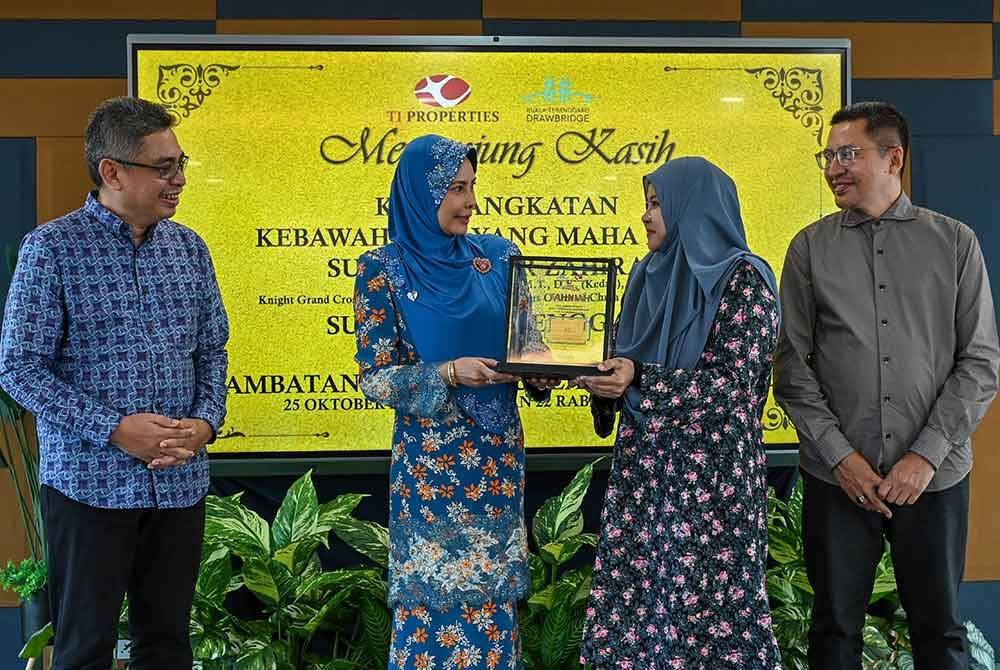 Sultanah Terengganu, Sultanah Nur Zahirah (dua, kiri) berkenan mengurniakan Gold Bar kepada pengunjung, Suriani Sulleh, 30 (dua, kanan) pada Majlis Pengurniaan Hadiah Kepada Pemenang Pengunjung Drawbridge Yang Ke Setengah Juta, pada Jumaat. Turut hadir, Ketua Pegawai Eksekutif Kumpulan Terengganu Inc, Burhanuddin Hilmi Mohamed@Harun (kiri). Foto Bernama