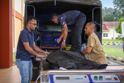 Anggota Polis Diraja Malaysia (PDRM) mengangkat mayat mangsa kemalangan untuk dibawa ke bilik mayat Hospital Gua Musang, pada Jumaat. Foto Bernama