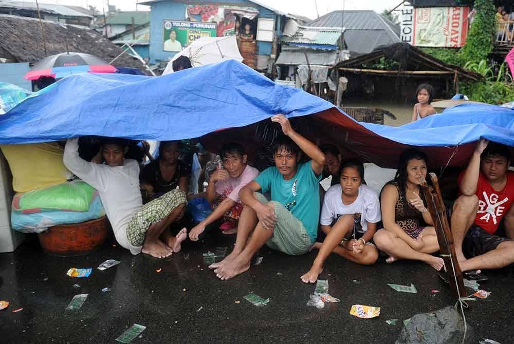 Penduduk yang terjejas berlindung di penempatan sementara di sepanjang jalan di Cavite, barat daya Manila.