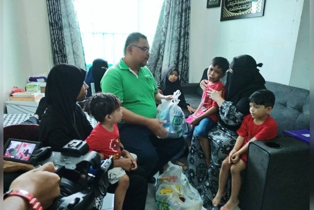 Mas Imran (duduk, tengah), menyampaikan sumbangan daripada pihak Econsave kepada Noorfazlin.