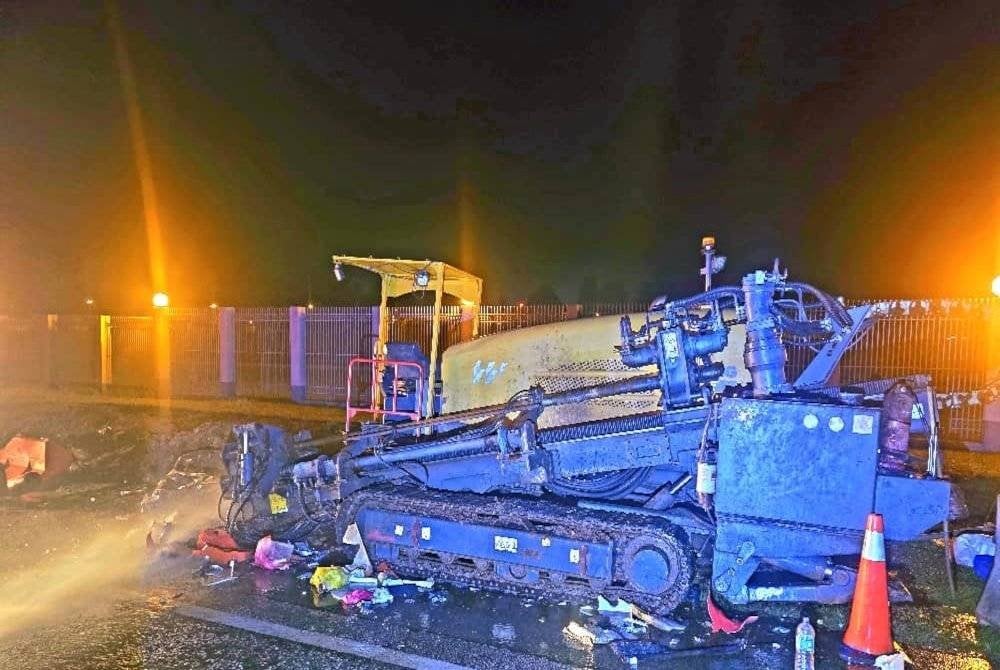 Jentera pengorek tanah yang diletakkan di bahu jalan. Foto JBPM Pahang