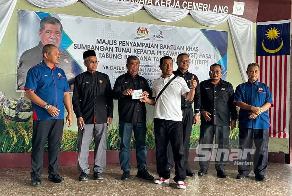 Simbolik Mohamad Sabu (tiga dari kiri) menyampaikan TBTP kepada petani di Kelantan.