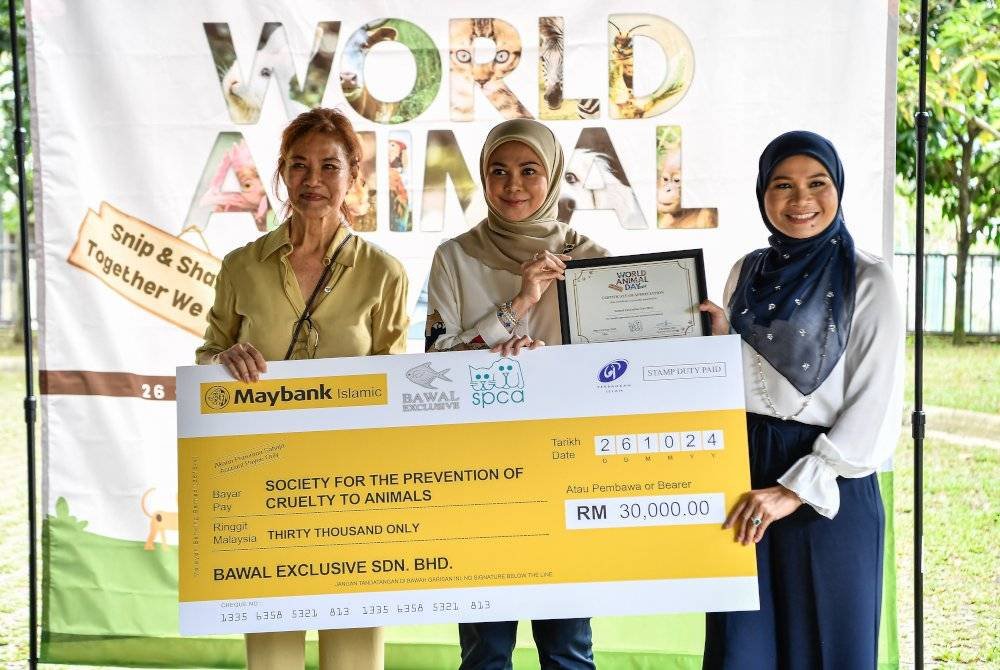 Tengku Permaisuri Norashikin (tengah) berkenan menyaksikan penyerahan replika cek daripada Pengasas Bawal Exclusive Sdn Bhd, Haliza Maysuri (kanan) kepada Christine Chin (kiri) pada Program Hari Haiwan Sedunia 2024 di SPCA hari ini. - Foto: Bernama