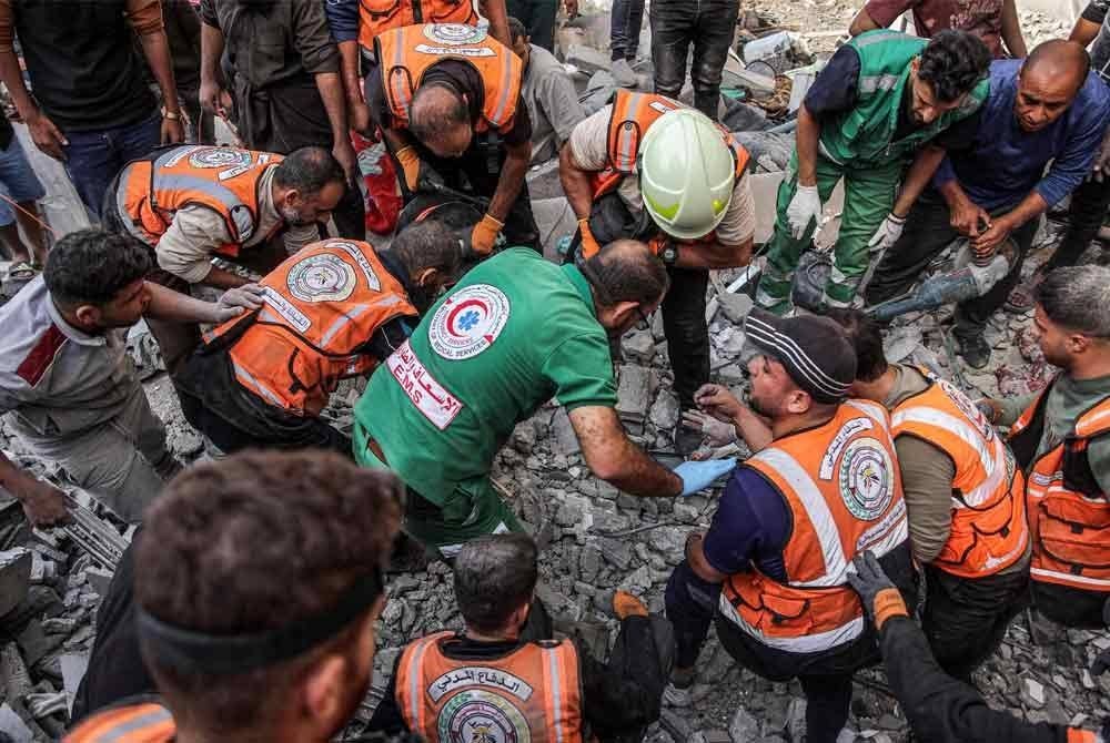 Anggota pertahanan awam Palestin mencari mangsa yang terselamat melalui runtuhan susulan pengeboman Israel ke atas rumah keluarga empat tingkat Muqat di kejiranan Zarqa di utara Kota Gaza pada Sabtu - Foto: AFP