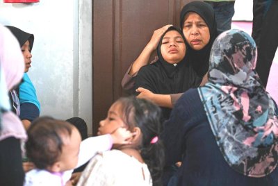 Nur Jihan Irdina ditenangkan ahli keluarganya ketika majlis pengebumian empat ahli keluarganya termasuk ibu saudaranya di Tanah Perkuburan Islam Payang Kayu di Kuala Berang, Hulu Terengganu.