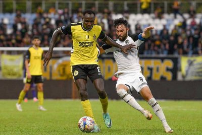 Pemain import pasukan Perak, Sunday Kolawole Afolabi (kiri) diasak pemain import pasukan Terengganu, Manuel Gelito Ott (kanan) pada perlawanan Perak FC menentang Terengganu FC dalam saingan Liga Super Malaysia 2024/2025 di Stadium Majlis Perbandaran Manjung hari ini. - Foto: Bernama