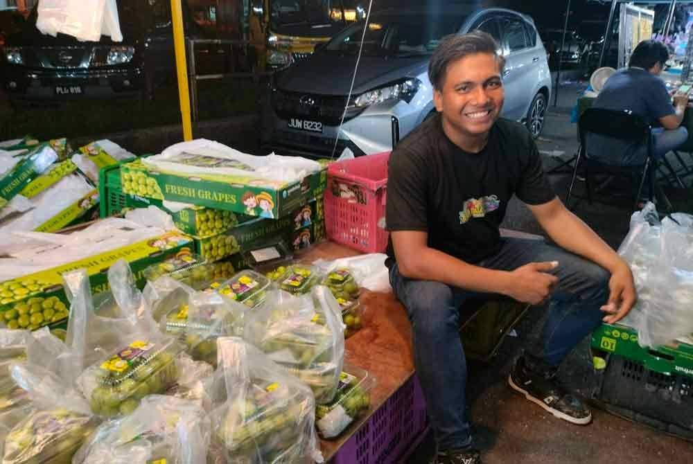 Faris bersama barangan jualan di sebuah tapak pasar malam di Sungai Petani, Kedah.
