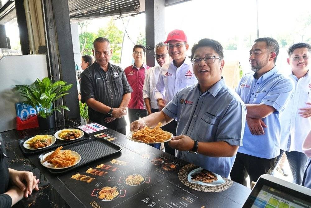 Ewon (kanan) menunjukkan antara menu yang ditawarkan di kafe Kosite.