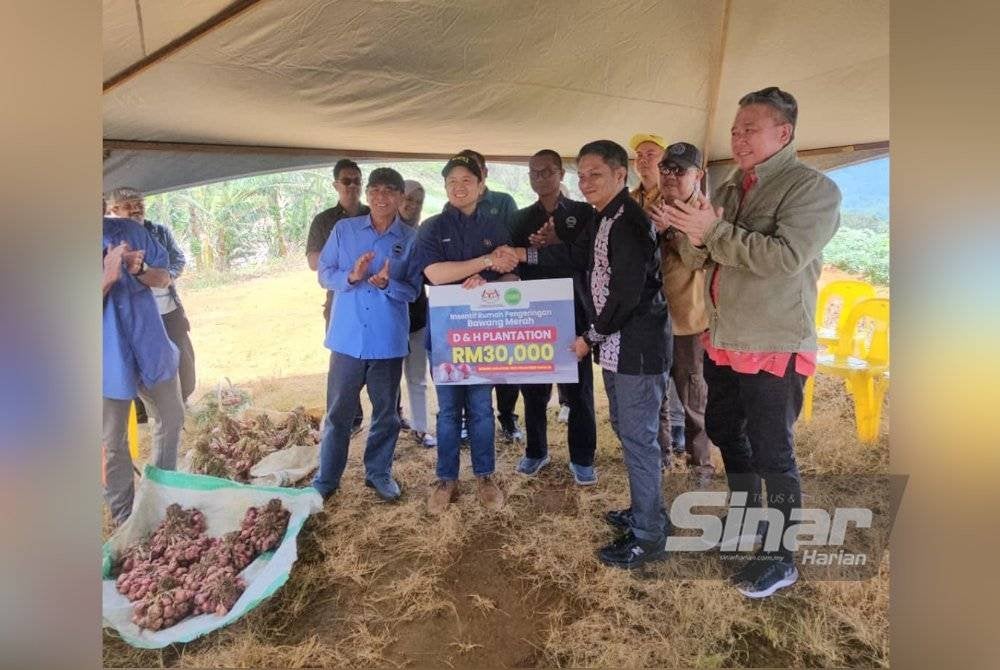 Syahrizal menerima insentif RM30,000 yang disampaikan Arthur untuk pembinaan rumah pengeringan bawang merah. FOTO SINAR HARIAN-ASYIKIN ASMIN