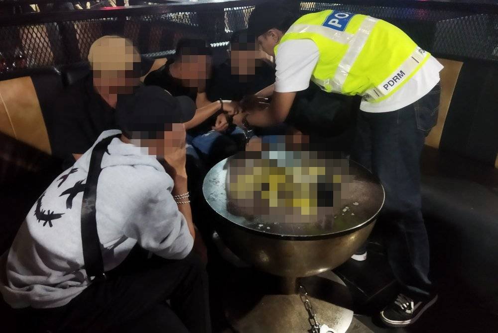 Antara pelanggan lelaki yang ditahan dalam serbuan di sebuah pusat hiburan di sini pada Ahad.