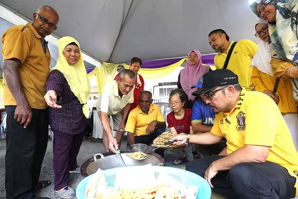 Penduduk berbilang kaum di Taman Rasa Sayang bergotong-royong membuat muruku sempena sambutan Deepavali.
