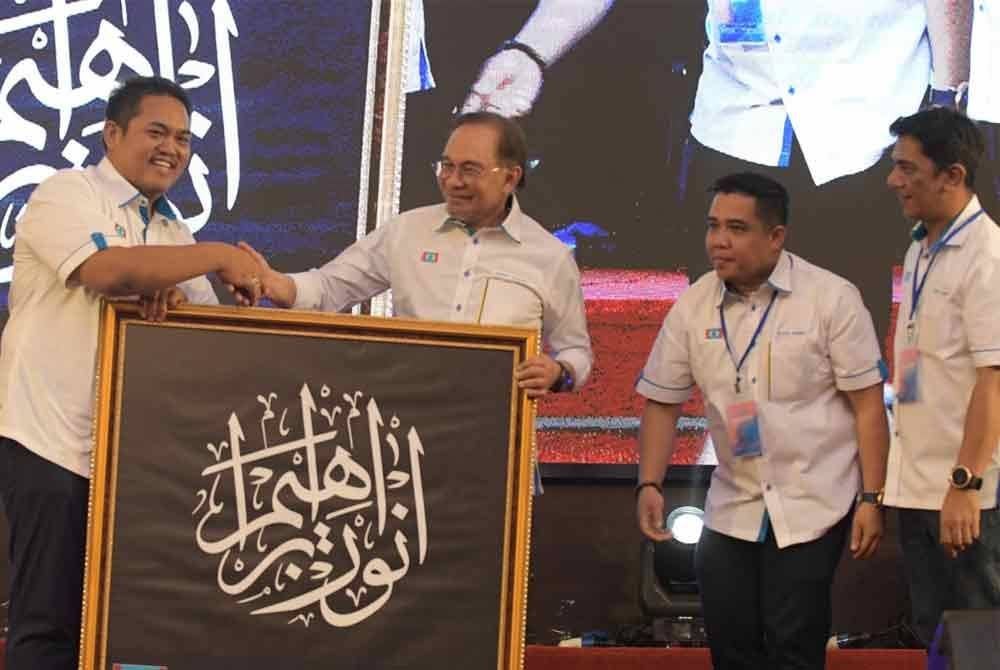 Anwar menerima cenderahati daripada Pengerusi PKR Perak, Mohamad Hairul Amir Sabri pada Konvensyen Keadilan Perak di Ipoh.