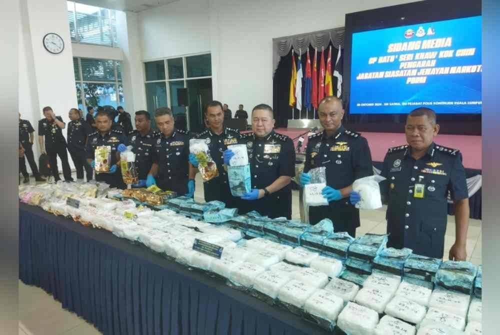 Khaw Kok Chin (tiga kanan) menunjukkan dadah yang dirampas.