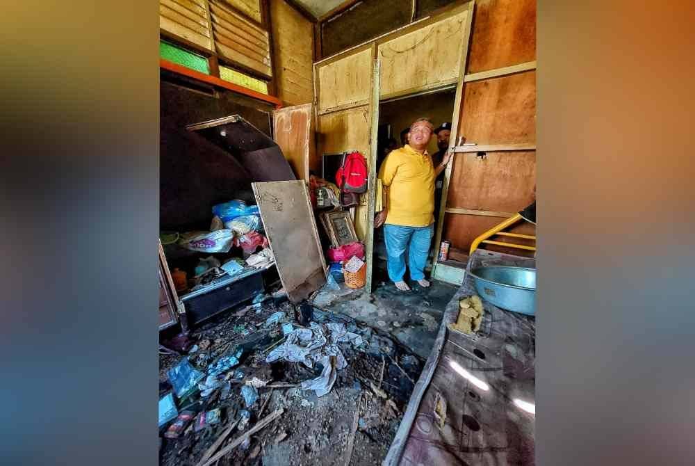 Rais melihat keadaan rumah Mazelan di Kampung Paya Mengkuang 2, Bukit Rambai, di sini, pada Ahad.