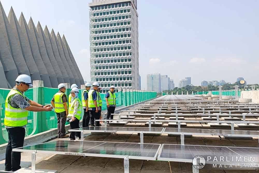 Johari (kanan) ketika meninjau panel solar yang dipasang di bangunan Parlimen