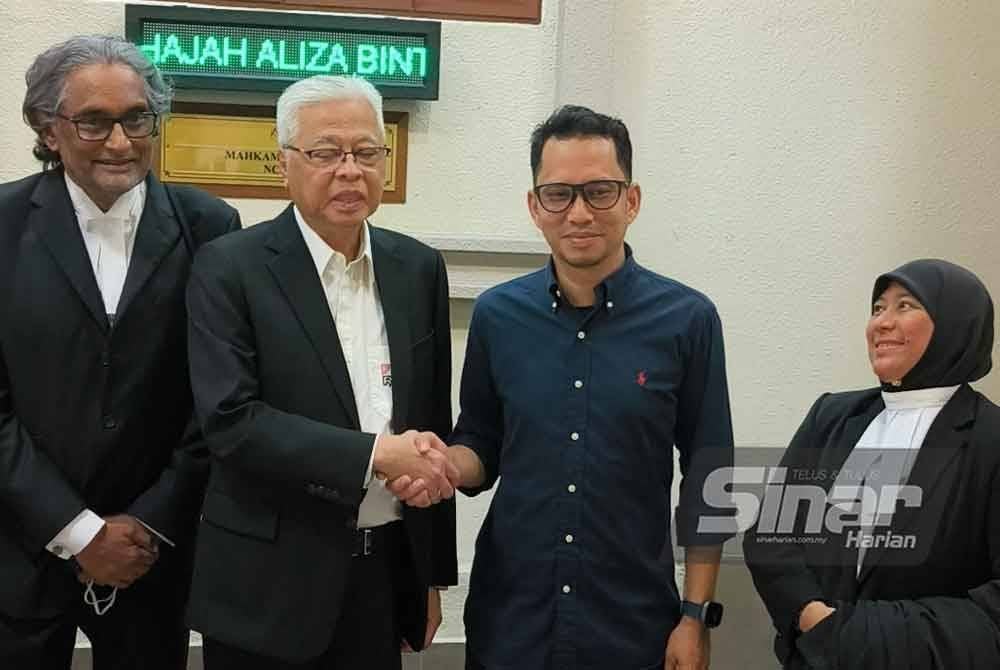 Ismail Sabri bersalaman dengan Muhamad Izwan di luar Mahkamah Tinggi Kuala Lumpur pada Isnin.
