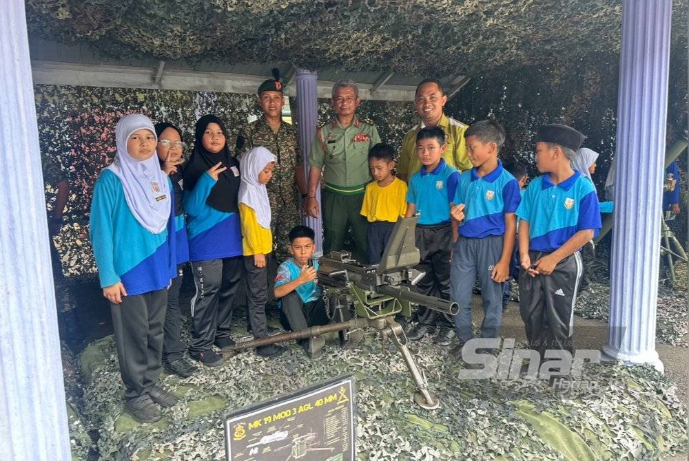 Mardzuki (tengah) meraikan anak-anak yang berminat melihat kelengkapan tentera. Foto Sinar Harian ADILA SHARINNI WAHID