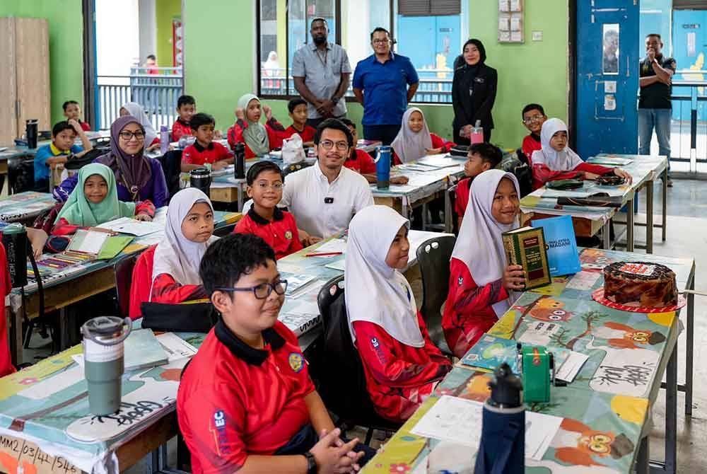 Kamil bergambar dengan murid ketika wakili Anwar di SK Presint 16. Foto Facebook Anwar Ibrahim