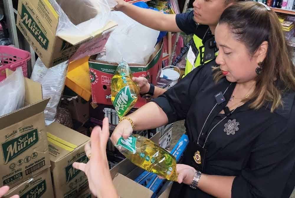 Norena (kiri) memeriksa minyak masak peket yang disyaki dijual kedai runcit kepada peniaga kedai makan yang diuruskan warga asing.