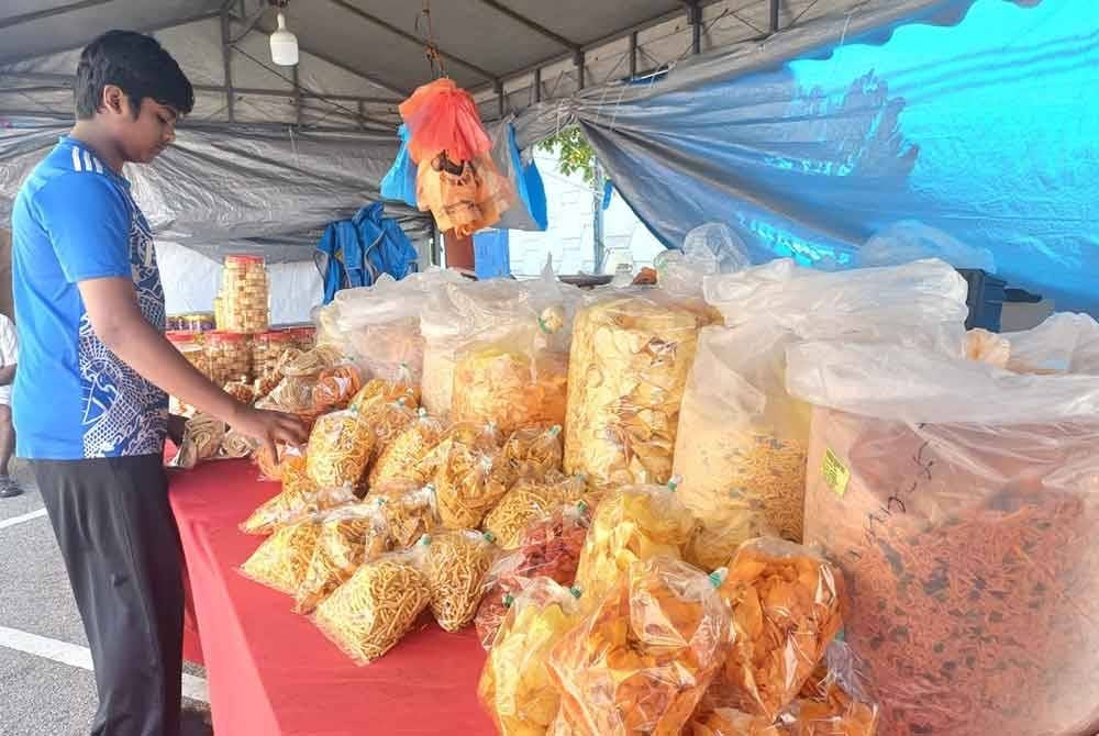Seorang pembantu kedai menyusun pelbagai jenis kerepek termasuk muruku yang dijual sempena sambutan Deepavali di Bandaraya Kuantan.