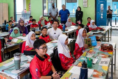 Kamil bergambar dengan murid ketika wakili Anwar di SK Presint 16. Foto Facebook Anwar Ibrahim